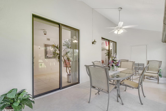 dining room featuring a ceiling fan, lofted ceiling, and tile patterned flooring