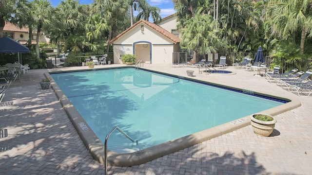 pool with a patio area and fence