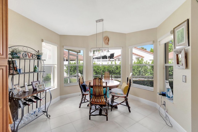 dining area featuring light tile patterned floors, baseboards, and vaulted ceiling