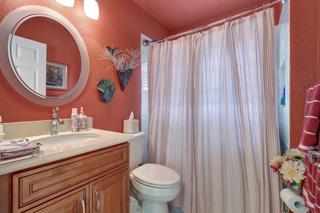 full bathroom featuring toilet, a textured wall, and vanity