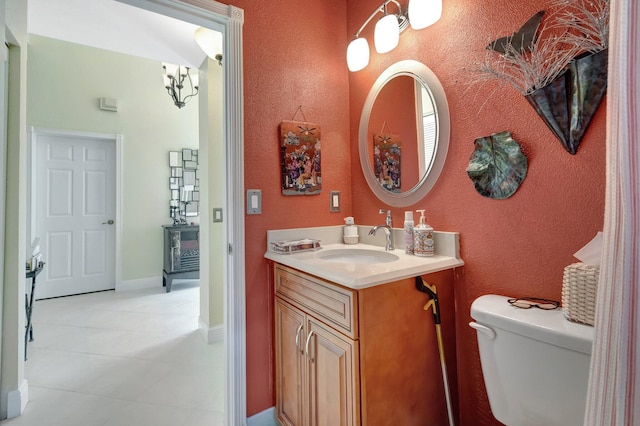 half bathroom featuring toilet, baseboards, and vanity