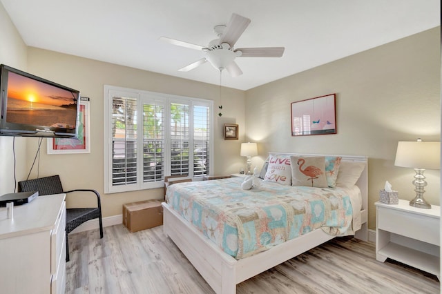 bedroom featuring baseboards, ceiling fan, and light wood-style floors