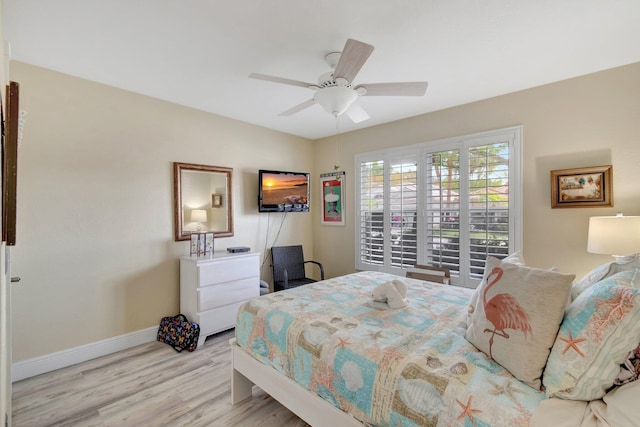 bedroom featuring wood finished floors, a ceiling fan, and baseboards