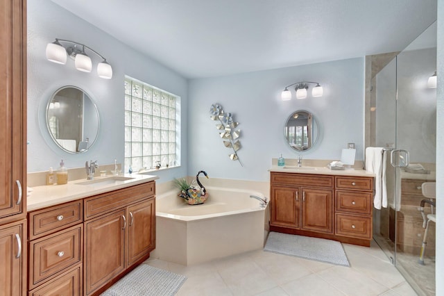 full bath with a stall shower, tile patterned flooring, two vanities, and a sink