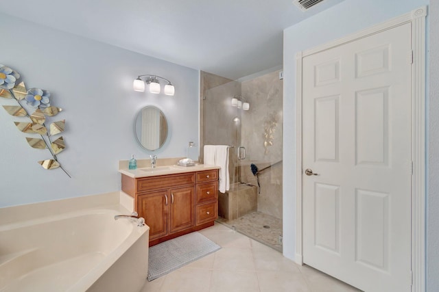 bathroom with a garden tub, a stall shower, tile patterned flooring, and vanity