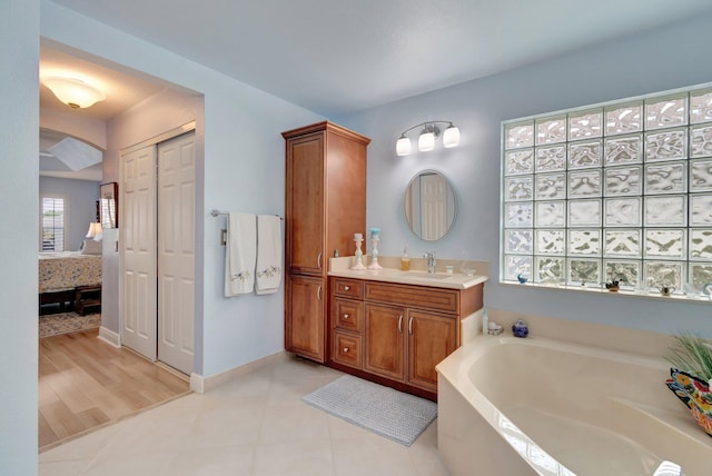 ensuite bathroom featuring ensuite bathroom, tile patterned flooring, vanity, and a bath