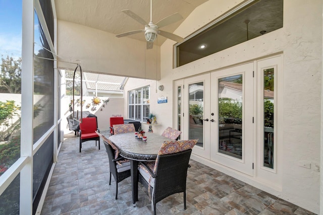 sunroom / solarium featuring a ceiling fan and french doors