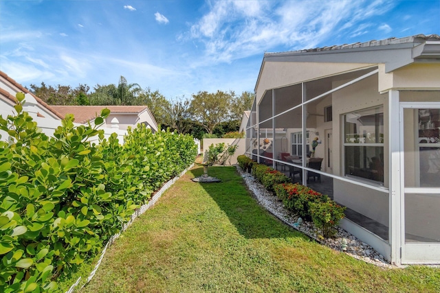 view of yard with a lanai and fence