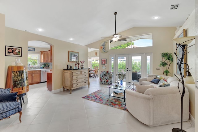 living room with lofted ceiling, light tile patterned flooring, arched walkways, and french doors