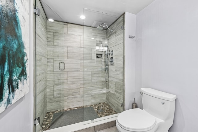 bathroom with a shower stall and toilet