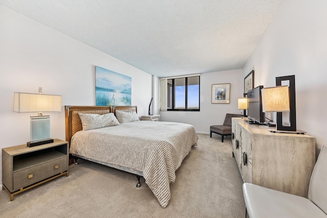 bedroom with light carpet and a textured ceiling