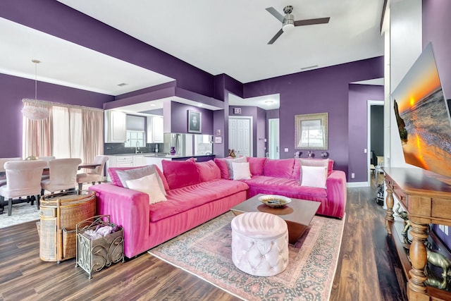 living area with ceiling fan, dark wood finished floors, and baseboards