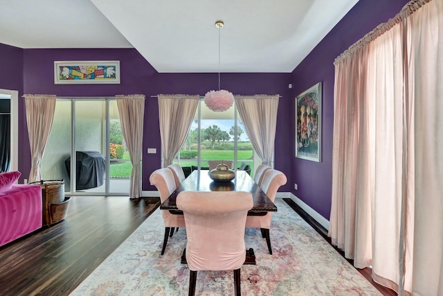 dining space with baseboards and wood finished floors