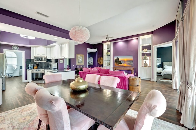 dining room featuring built in features, visible vents, dark wood finished floors, and a ceiling fan