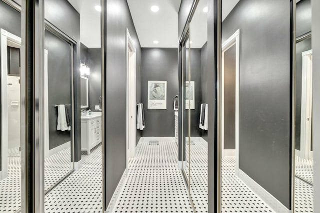 bathroom with baseboards, a shower stall, vanity, and recessed lighting