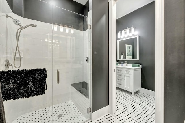 full bathroom with a stall shower, vanity, baseboards, and tile patterned floors