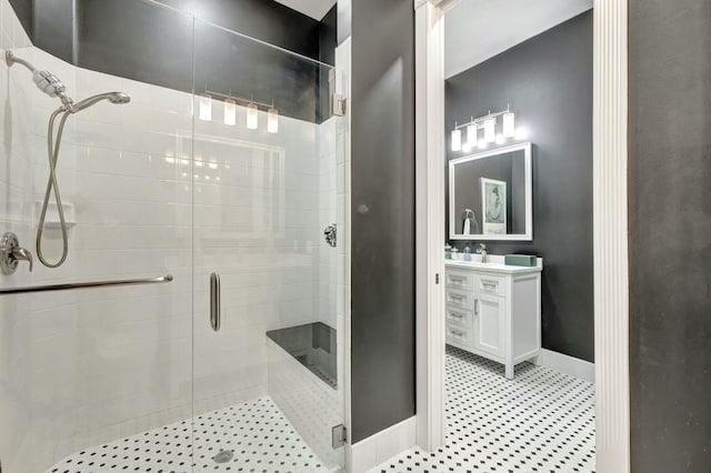 bathroom with baseboards, a shower stall, and vanity