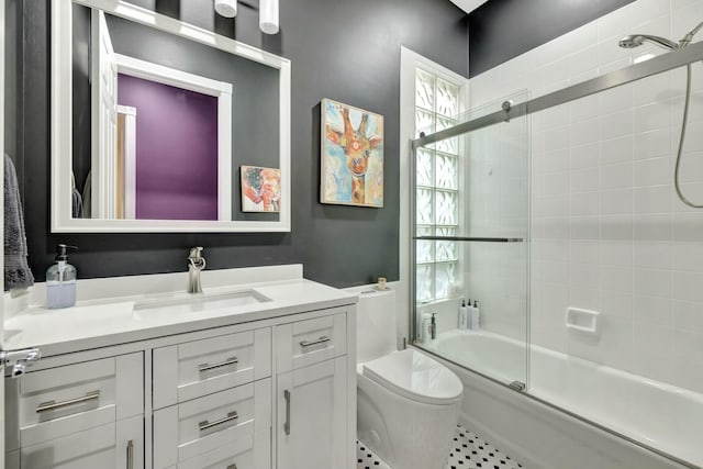 full bath with toilet, shower / bath combination with glass door, and vanity