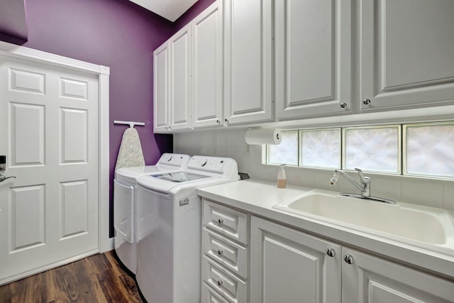 laundry room with cabinet space, dark wood finished floors, washer and clothes dryer, and a sink