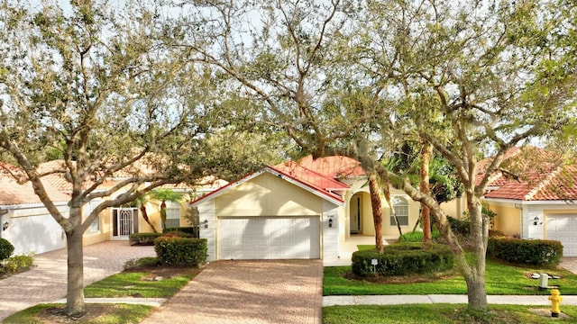 view of front of house with a garage, decorative driveway, and stucco siding