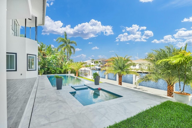 outdoor pool with a patio area and a water view