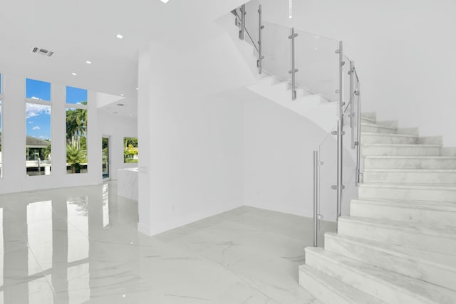 stairway with marble finish floor, visible vents, and recessed lighting