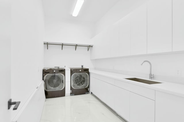 clothes washing area with marble finish floor, cabinet space, washer and clothes dryer, and a sink