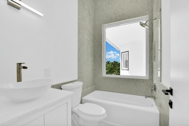 bathroom with toilet, vanity, and a bathtub