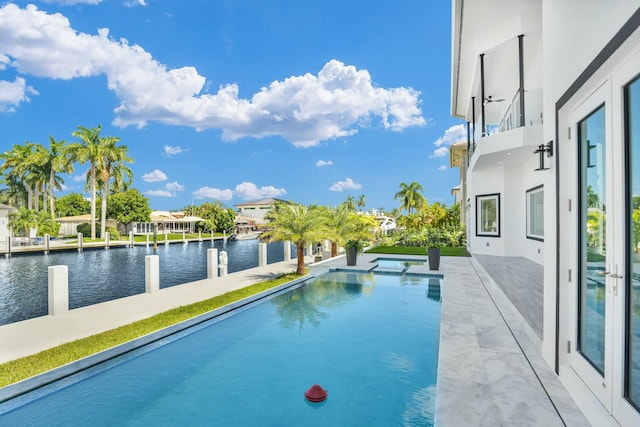 view of swimming pool featuring a water view, an infinity pool, and a patio