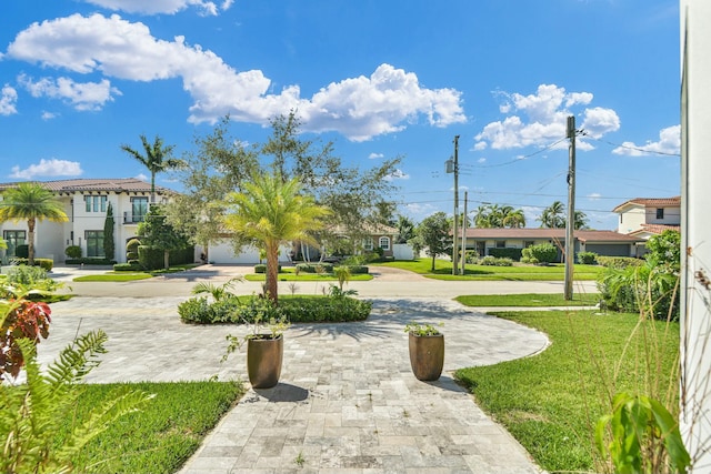 view of home's community featuring driveway and a lawn