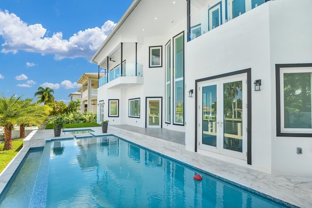 view of pool with french doors, a patio area, and a pool with connected hot tub