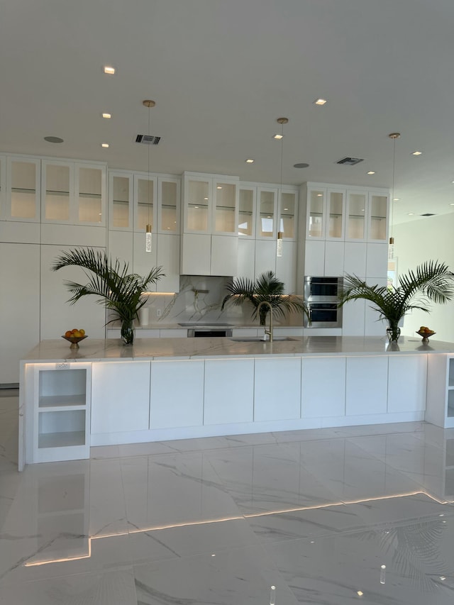 interior space with a spacious island, visible vents, white cabinets, marble finish floor, and modern cabinets