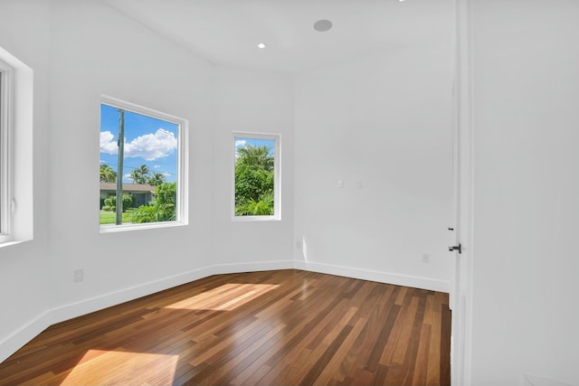 spare room with recessed lighting, hardwood / wood-style flooring, and baseboards