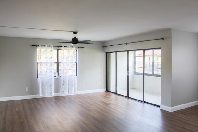 empty room featuring a ceiling fan, baseboards, and wood finished floors