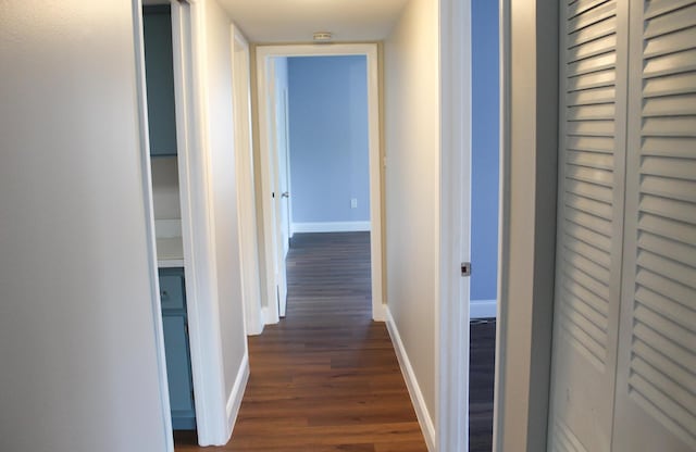 hall with baseboards and dark wood finished floors