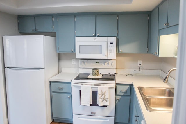 kitchen featuring light countertops, white appliances, blue cabinetry, and a sink