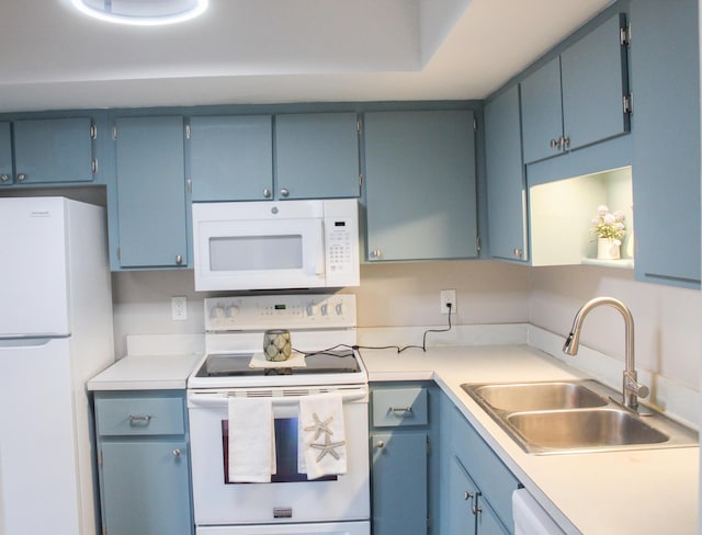 kitchen featuring white appliances, light countertops, and a sink