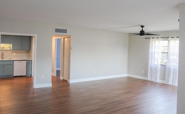 interior space with visible vents, a ceiling fan, dark wood-type flooring, a sink, and baseboards