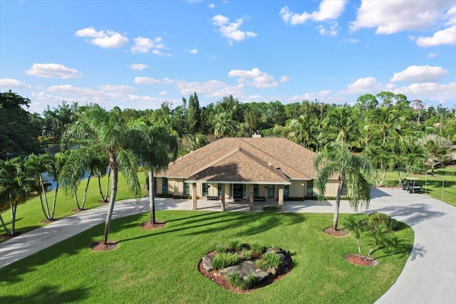 view of front of house featuring concrete driveway and a front lawn