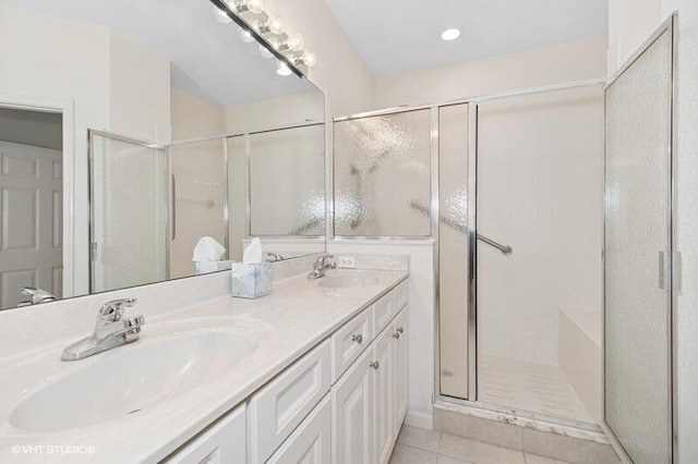 bathroom with a stall shower, tile patterned floors, a sink, and double vanity