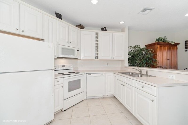 kitchen with light countertops, visible vents, a sink, white appliances, and a peninsula