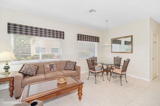 living area featuring light tile patterned flooring, visible vents, and baseboards