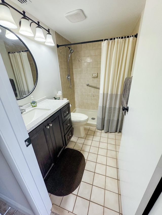 bathroom with tile patterned flooring, a shower stall, toilet, and vanity