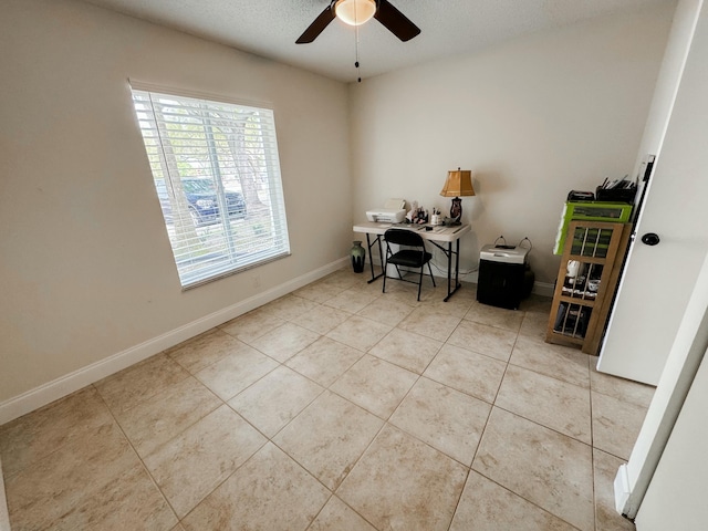 home office with ceiling fan, baseboards, and light tile patterned flooring