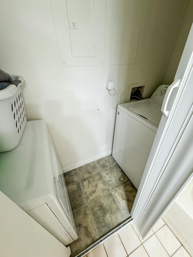 laundry area featuring tile patterned flooring, laundry area, baseboards, washer and dryer, and electric panel