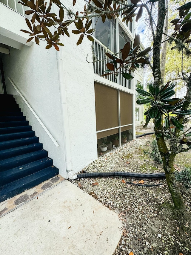 view of home's exterior featuring stairs and stucco siding