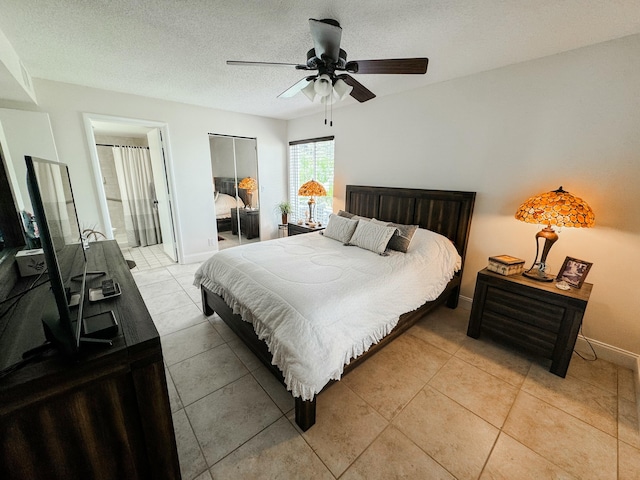 bedroom featuring a ceiling fan, a textured ceiling, baseboards, and light tile patterned floors