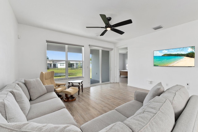 living room featuring a ceiling fan, visible vents, and wood finished floors