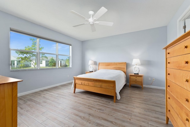 bedroom featuring light wood-style floors, ceiling fan, and baseboards