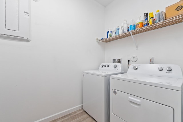 washroom featuring laundry area, light wood finished floors, washing machine and dryer, and baseboards